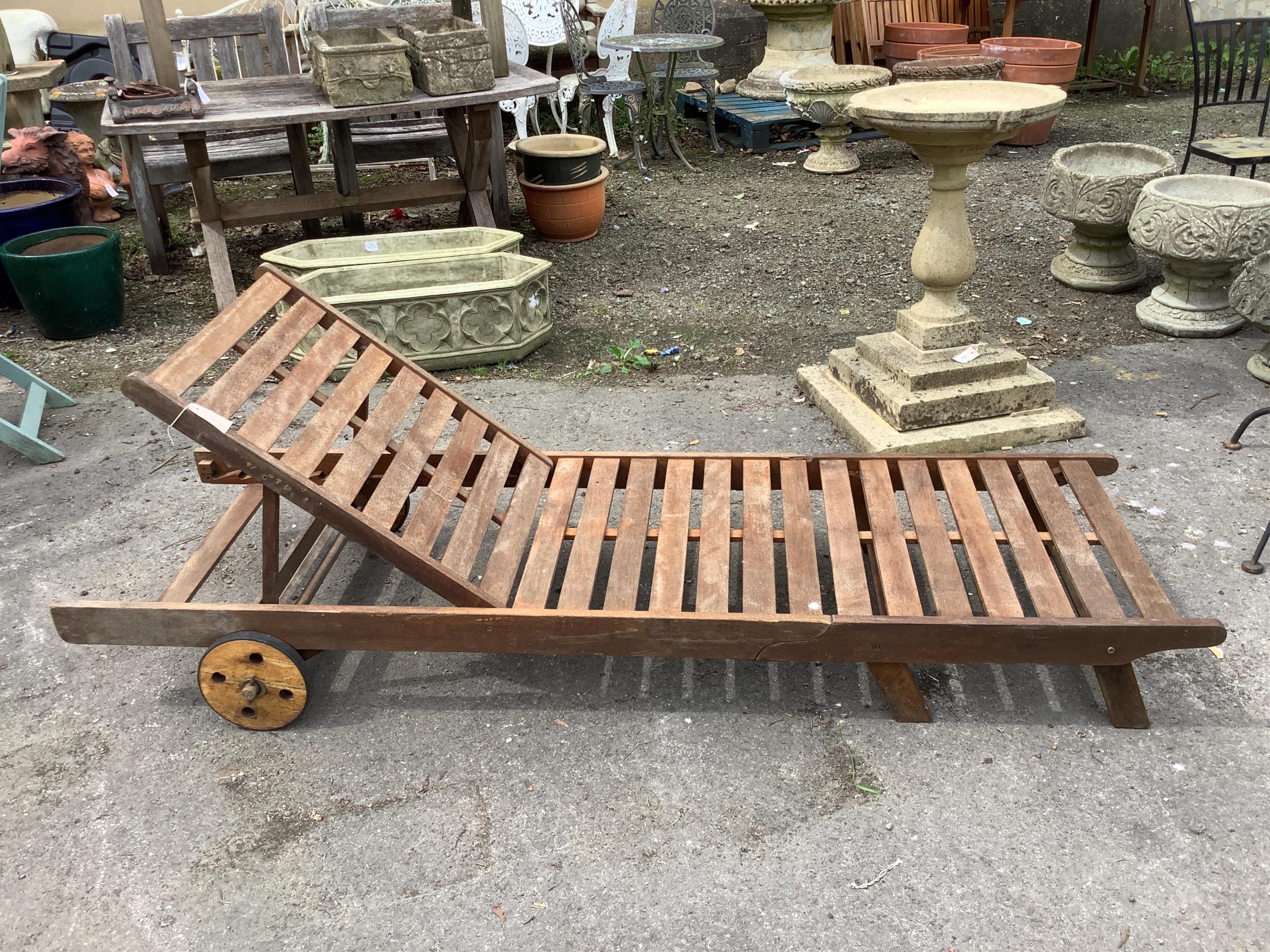 A weathered teak garden lounger chair